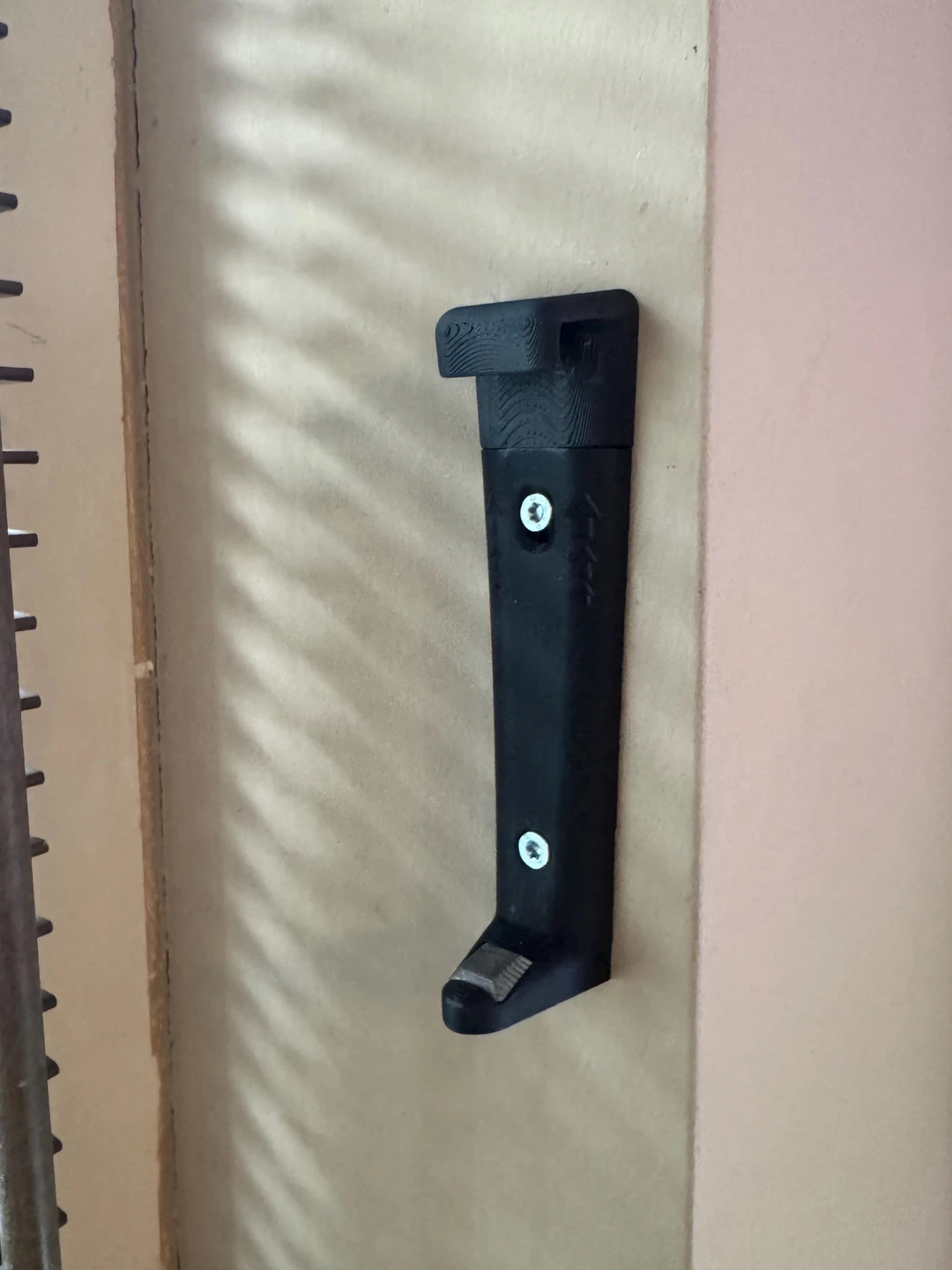 Schwarze gedruckte Blumentopfhalterung ohne Topf, mit oberer und unterer Aufnahme sowie zwei sichtbaren Befestigungsschrauben an der Wand