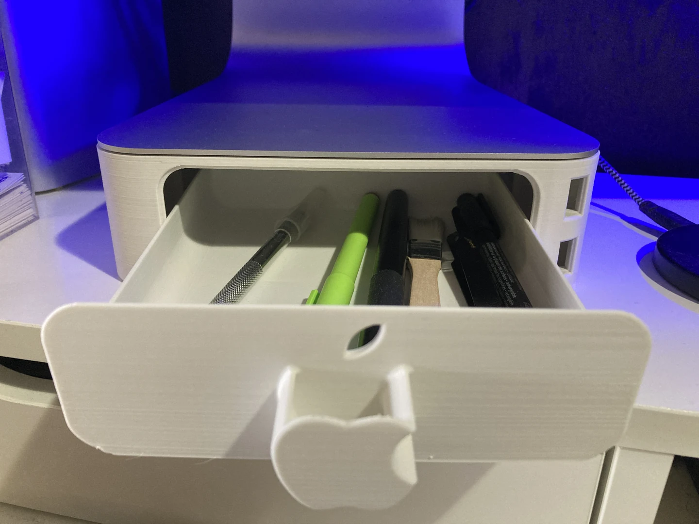 Gefertigter weißer iMac-Ständer mit geöffneter Schublade und Schreibutensilien
