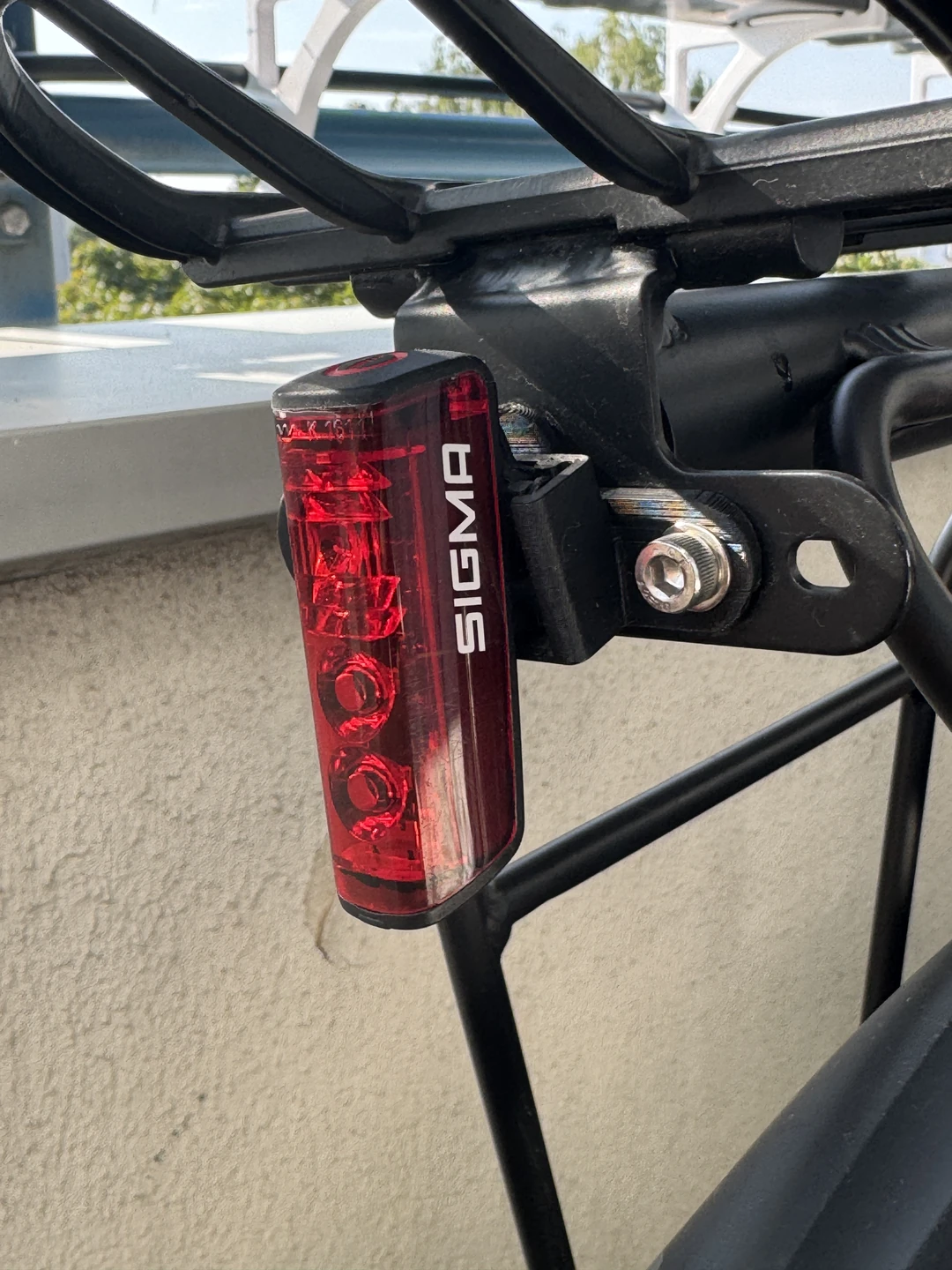 SIGMA-BLAZE-Rücklicht im gedruckten Adapter am Gepäckträger eines Fahrrads